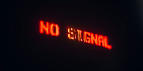 Ein Foto mit einer Nahaufnahme eines roten Schriftzugs "No Signal" auf einem Monitor.