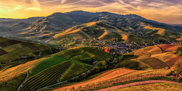 Eine Foto zeigt eine hüglige Landschaft, in der Dörfer und Weiler mit Strassen und Wegen verbunden sind.